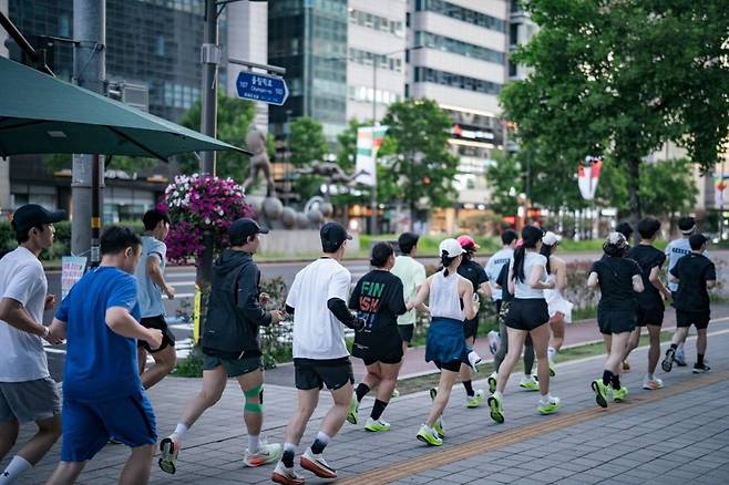서울 송파구 일대에서 '나이키 런클럽 롯데월드타워' 참여자들이 러닝을 하고 있다. 롯데백화점 제공.