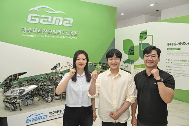 광주미래차모빌리티진흥원에서 근무하는 오지우(왼쪽부터)씨, 민현우씨, 장웅선씨가 모빌리티 핵심 부품이 전시돼 있는 진흥원 1층에서 기념 촬영을 하고 있다. /김진수 기자 jeans@kwangju.co.kr