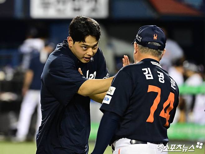 22일 오후 서울 송파구 잠실야구장에서 열린 '2025 신한 SOL Bank KBO리그' 한화 이글스와 두산 베어스의 경기, 한화가 선발투수 문동주의 6이닝 무실점 호투에 힘입어 2:1의 스코어로 승리하며 구단 최초 단일 시즌 두 차례 10연승을 달성했다. 경기 종료 후 한화 문동주가 김경문 감독과 승리의 기쁨을 나누고 있다. 엑스포츠뉴스DB