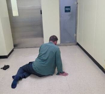 부산 남부경찰서 문현지구대가 지난달 25일 보호조치와 응급실 입원까지 도운 외국인 남성의 뒷모습. 당시 병원 응급실로, A 씨는 정신질환을 앓고 있어 바닥에 드러눕는 등 이상 증세를 보였던 것으로 전해졌다. 부산 남부경찰서 제공