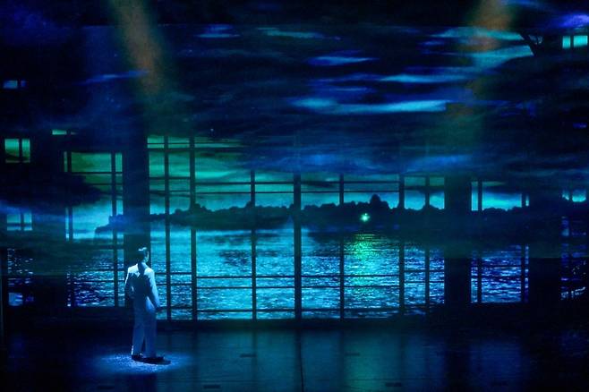 뮤지컬 ‘위대한 개츠비’의 오프닝에 나오는 장면. 개츠비가 창문 너머로 데이지의 집에서 나오는 녹색 불빛을 바라보고 있다. (c)오디컴퍼니