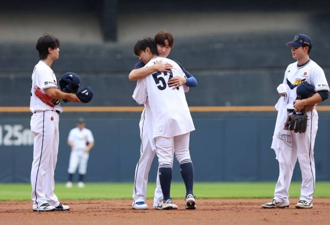 지난달 8일 김재호(가운데)의 은퇴식에서 52번이 적힌 유니폼을 물려받고 있는 박준순과 지켜보는 이유찬(왼쪽)과 오명진. /사진=두산 베어스 제공