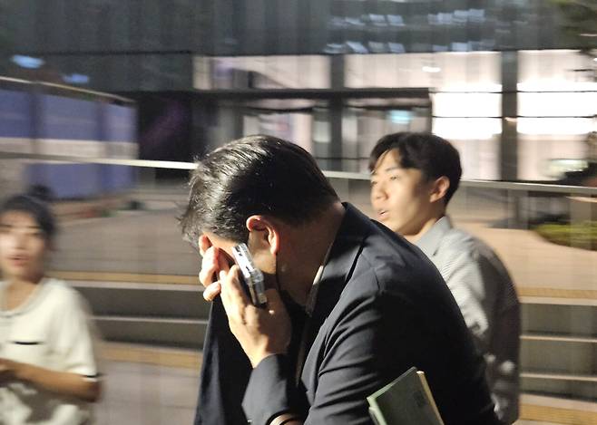 김건희씨 오빠인 김진우씨가 7월28일 김건희 특검으로부터 조사를 받은 뒤 얼굴을 가린 채 특검 사무실을 나서고 있다. ⓒ연합뉴스