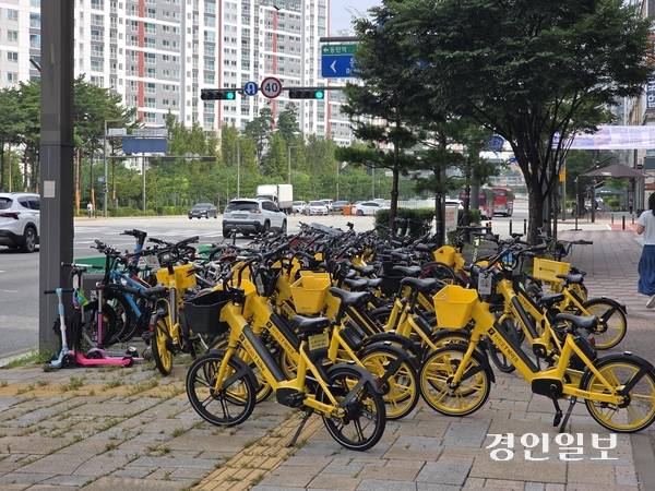 18일 오전 화성시 동탄 목동의 버스정류장 인근 개인형 이동장치(PM)가 쌓여 있는 모습. 5개 노선의 광역버스가 정차하는 이곳에는 15대가량 주차할 수 있는 반납대가 있지만, 50대 이상의 킥보드와 자전거가 몰렸다. 이날부터 PM 지정위치 대여·반납제 시행됐지만, 반납대가 부족하고 정책 인지도가 낮아 준수율이 미미한 상태였다.2025.8.18 /고건기자 gogosing@kyeongin.com