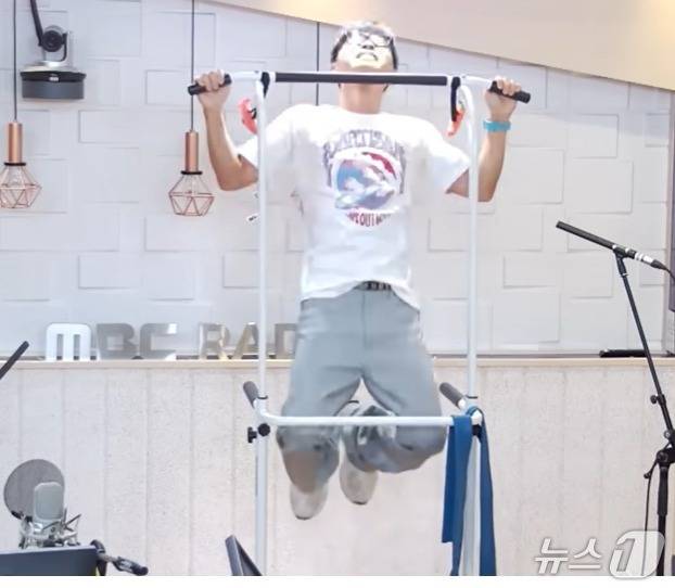 가수 이승환이 18일 오후 MBC라디오 '권순표의 뉴스 하이킥' 스튜디오에서 턱걸이를 하고 있는 모습. 이날 이승환은 턱걸이를 21개나 했다. (유튜브 갈무리) ⓒ 뉴스1