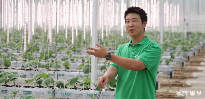 충남 보령시에서 스마트팜을 운영하는 서원상 씨가 인공지능(AI)과 정보통신기술을 접목한 그의 오이 농장 앞에서 재배 방식을 설명하고 있다. 서 씨 뒤로 보이는 세로 1m 길이의 발광다이오드(LED) 조명은 흐린 날 부족한 햇빛을 보완해 생육에 필요한 광량을 꾸준히 공급한다. 보령=박형기 기자 oneshot@donga.com