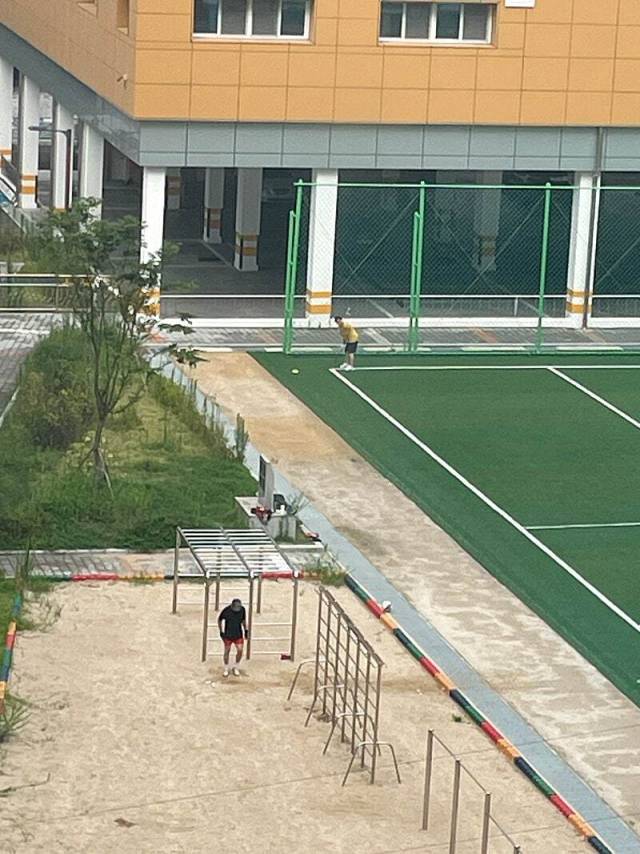 지난 5일 부산 해운대구 A 초등학교 운동장에서 성인 남성 2명이 골프 연습을 하는 모습. 온라인 커뮤니티 캡처