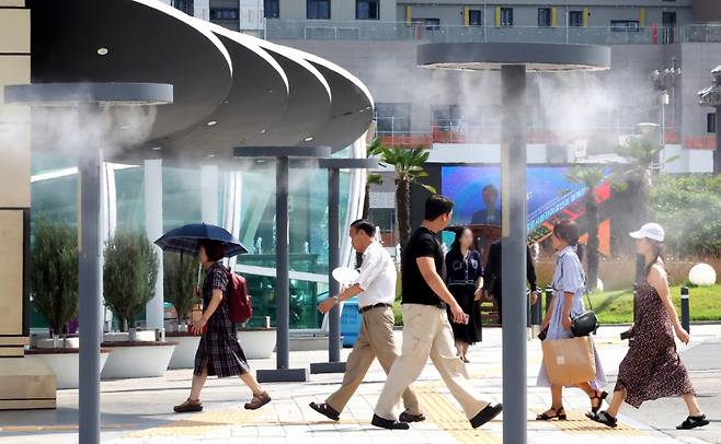 폭염이 연일 계속되고 있는 25일 대구 동구 동대구역 광장에 설치된 쿨링포그 아래로 시민들이 이동하고 있다. /사진=뉴시스