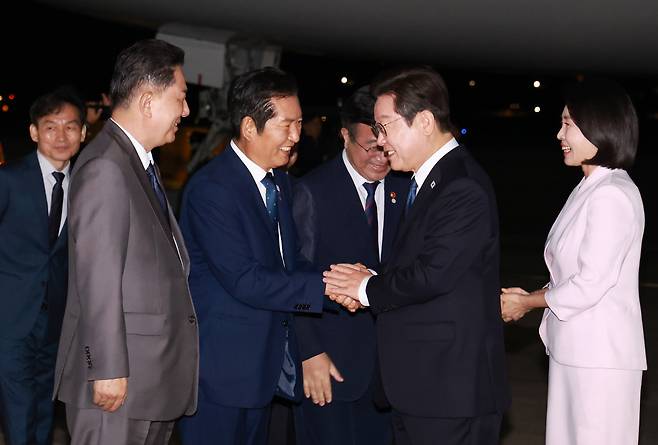 이재명 대통령 부부가 28일 성남 서울공항에 도착해 민주당 지도부와 인사하고 있다.