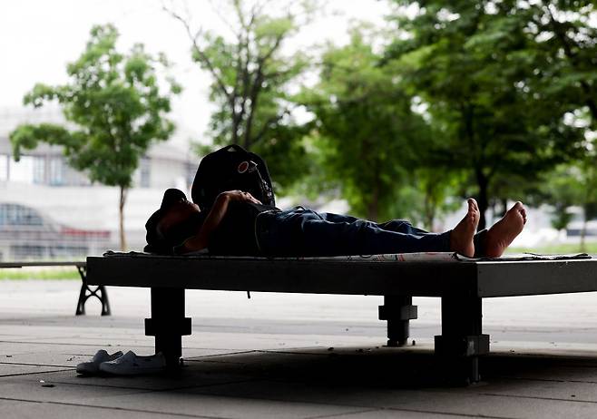지난달 21일 서울 영등포구 여의도한강공원에서 한 시민이 그늘에서 휴식을 취하고 있다. 연합뉴스