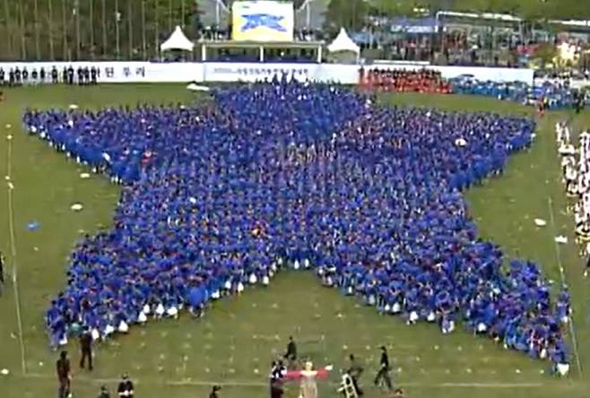 Hundreds of Samsung Electronics new recruits take part in a large-scale cheering performance during the company’s 2006 summer retreat. (YouTube)