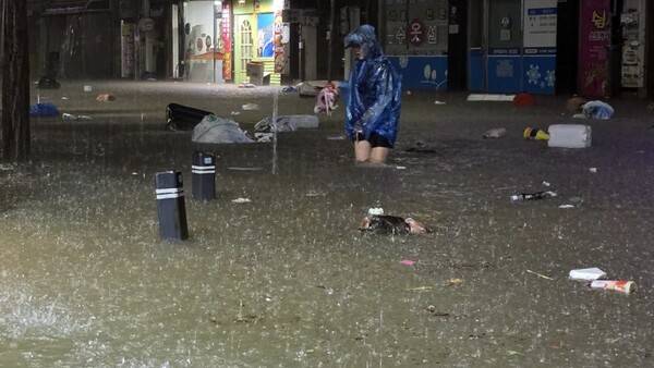 무안군을 중심으로 광주·전남 곳곳에 극한호우가 쏟아진 지난달 3일 광주 북구 운암동 도심에서 한 시민이 침수된 거리를 이동하고 있다. 연합뉴스