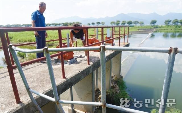 전남 담양군 수북면에 있는 소록보에서 수리시설 감시원 김재중씨(오른쪽)와 조길석씨가 수문을 열고 있다. 수동인 데다 수문 아래 침전물이 끼어 있어 작동이 더 어렵다.