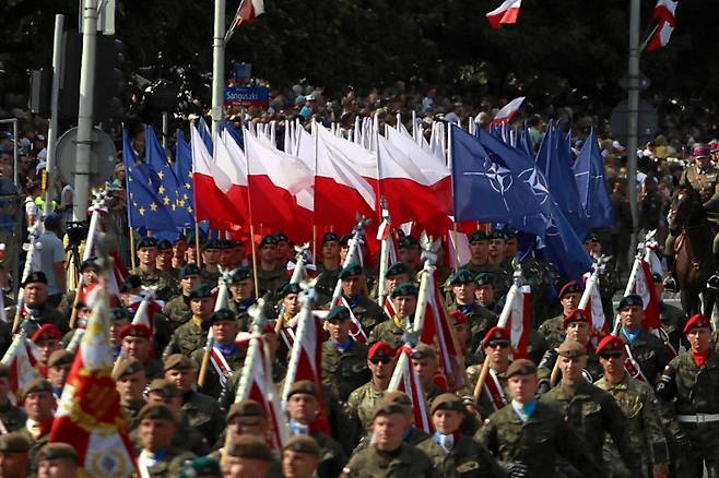 폴란드 국군의 날 군사 퍼레이드에 참가한 폴란드 군인들이 폴란드, NATO, EU 국기 앞에서 행진하고 있다. /연합뉴스