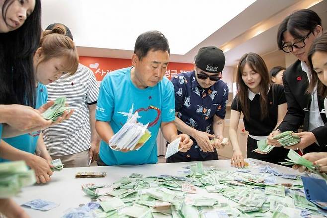 가수 박상민씨와 개그맨 황기순씨가 직원들과 함께 '사랑더하기' 거리 모금 성금을 집계하고 있다. 사랑의열매 제공