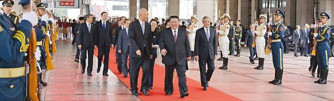 <국빈급 영접> 김정은 북한 국무위원장이 2일 중국에 도착해 중국 공산당 간부들의 영접을 받으며 베이징역을 나오고 있다. 앞줄 왼쪽부터 차이치 공산당 중앙서기처 서기, 김정은, 왕이 외교부 장관. 조선중앙통신 연합뉴스