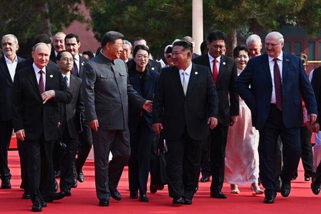 김정은 북한 국무위원장이 3일(현지 시간) 시진핑 중국 국가주석과 얘기하며 '중국 인민 항일 전쟁 및 세계 반파시스트 전쟁 승리(전승절)' 80주년 기념 열병식이 열리는 베이징 톈안먼 광장으로 걸어오고 있다. 베이징=AP 뉴시스