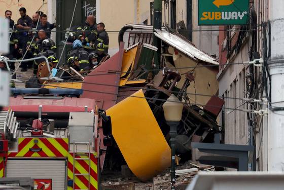 3일(현지시간) 포르투갈 리스본에서 발생한 푸니쿨라(케이블 전차) 탈선 사고 현장에서 경찰과 소방대원들이 구조 작업을 벌이고 있다. AFP=연합뉴스