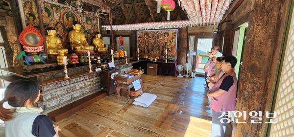 템플스테이 참가자들이 봉사자와 함께 경내를 둘러보며 설명을 듣고 있다. 2025.8.22 /김성호기자 ksh96@kyeongin.com