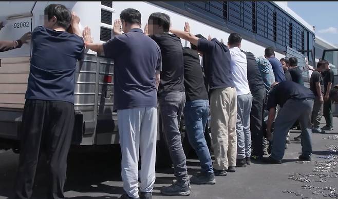 5일 미국 이민세관단속국(ICE)가 홈페이지에 공개한 조지아주 현대차와 LG에너지솔루션이 함께 건설 중인 전기차 배터리 공장 건설 현장의 단속현장, 쇠사슬로 묶고 가는 모습도 보인다./ICE홈페이지