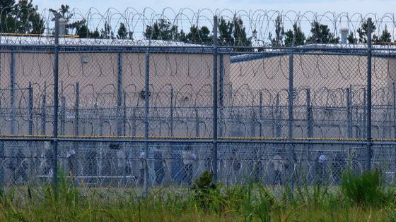 현지 시간 6일 미국 조지아주 포크스턴에 위치한 불법 체류자 구금 시설에서 지난 4일 체포된 한국인 근로자 300여명이 30여명씩 그룹을 나눠 추가 조사를 받기 위해 줄을 서 있다. 30도가 넘는 무더위 속에 이들은 푸른색 수용복 중 상의는 벗고 하의만을 착용했고, 손에는 서류를 한장씩 들고 있었다. 포크스턴=강태화 특파원