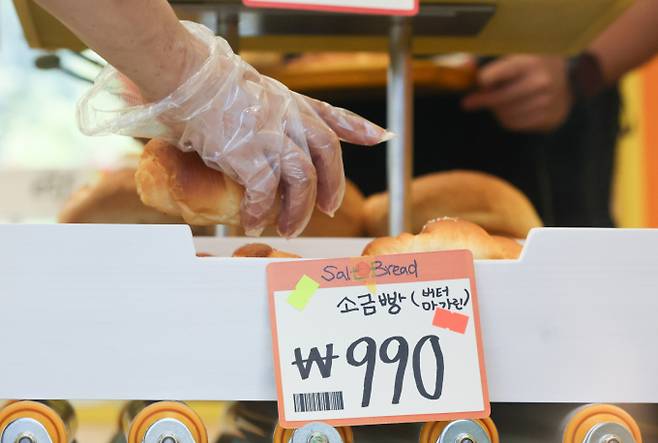 공정거래위원회가 발표한 제빵산업 시장분석 및 주요규제에 대한 경쟁영향평가보고서에 따르면 한국의 빵값이 다른 나라에 비해 100원 이상 비싼 수준으로 나타났다. 업계에서는 높은 인건비와 원재료 등 비교 국가들과 상황이 다른 점을 들어 억울함을 호소하고 있다. 서울 성동구 글로우 성수에 마련된 유튜버 '슈카월드'의 베이커리 팝업 스토어 ETF베이커리를 찾은 시민들이 990원에 판매되는 소금빵을 고르는 모습./사진=뉴시스