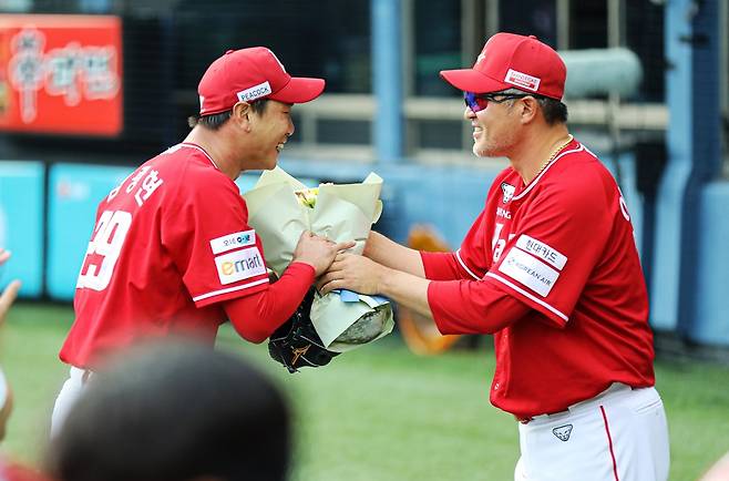 SSG 랜더스 김광현(왼쪽)이 7일 서울 잠실야구장에서 열린 2025 신한 SOL Bank KBO리그 LG 트윈스와의 팀 간 16차전에 선발등판, KBO리그 역대 세 번째 2000탈삼진을 달성한 뒤 이숭용 감독에게 축하 받는 모습. 사진 SSG 랜더스