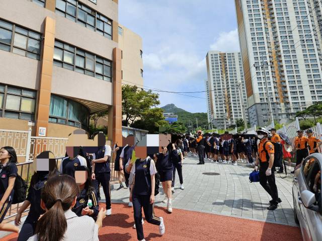 8일 부산 북구 A중학교 학생들이 폭발 테러 예고 사실이 알려진 직후 학교 밖으로 대피하고 있다. 부산소방재난본부 제공