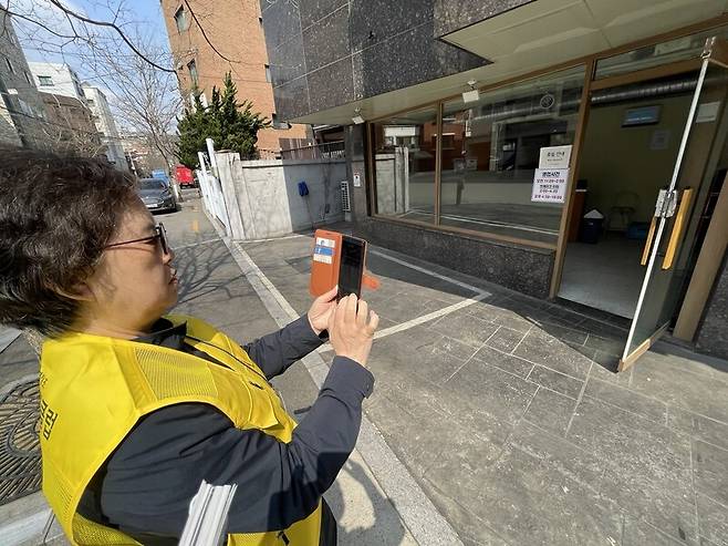 보행로 정보수집 업무 중인 김 어르신이 건물 진입로에 대한 기록을 앱에 남기고 있다. 황보연 기자