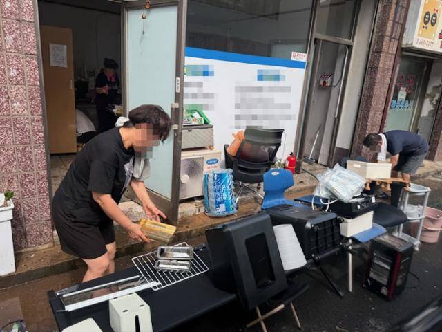 전북 군산시 나운동 상가들이 7일 밤사이 시간당 150㎜ 내린 폭우로 침수 피해를 입어 상인들이 물에 젖은 집기 등을 말리기 위해 밖으로 빼내고 있다. 독자 제공