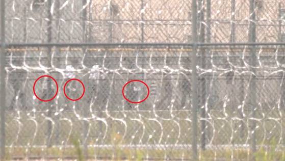 현지시간 8일 미국 조지아 현대차-LG에너지솔루션의 합작 배터리 공장 직원들이 수감된 포크스턴 수용시설에 근로자들이 푸른색 수용복 차림으로 줄을 서서 조사를 기다리고 있다. 이들의 손에 서류를 들고 있었다. 포크스턴=강태화 특파원