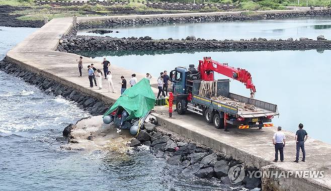 제주 해안서 발견된 정체불명의 보트 (서귀포=연합뉴스) 박지호 기자 = 해경과 경찰 등 관계자들이 8일 오전 제주시 한경면 용수리 해안가에서 이날 오전 발견된 미확인 보트를 조사해 인양하려 하고 있다.
해경은 밀입국, 해양사고 등의 가능성을 열어 놓고 조사하고 있다고 밝혔다. 2025.9.8 jihopark@yna.co.kr