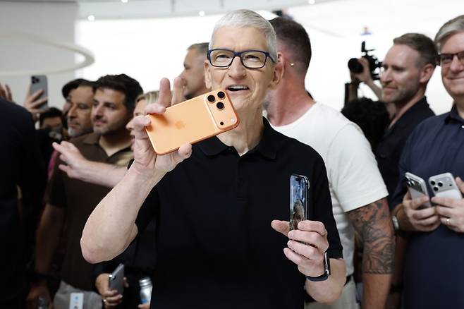 팀 쿡 애플 최고경영자(CEO)가 9일(현지시간) 미국 캘리포니아주 쿠퍼티노 애플파크에서 열린 신제품 발표회에서 신제품 아이폰을 보여주고 있다. 〈EPA 연합뉴스〉