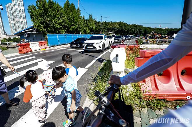 서울시가 서부간선도로 일반도로화 및 친환경공간 조성 사업을 중단하고 원상회복하겠다고 밝힌 가운데 10일 서울 영등포구 서부간선도로 오목교 건널목에서 어린이들이 길을 건너고 있다.