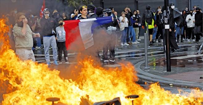 프랑스에서 ‘국가 마비’ 운동이 벌어진 가운데 10일(현지시간) 북부 도시 릴의 거리에서 한 남성이 프랑스 국기를 들고 시위하고 있다. /AP연합뉴스