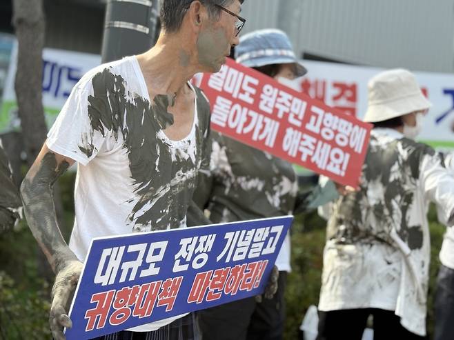 ▲ 갯벌 진흙을 온몸에 묻힌 월미도 원주민 귀향대책위원회 회원들이 15일 오후 인천 중구 상상플랫폼 주차장 입구에서 귀향 대책을 요구하고 있다.