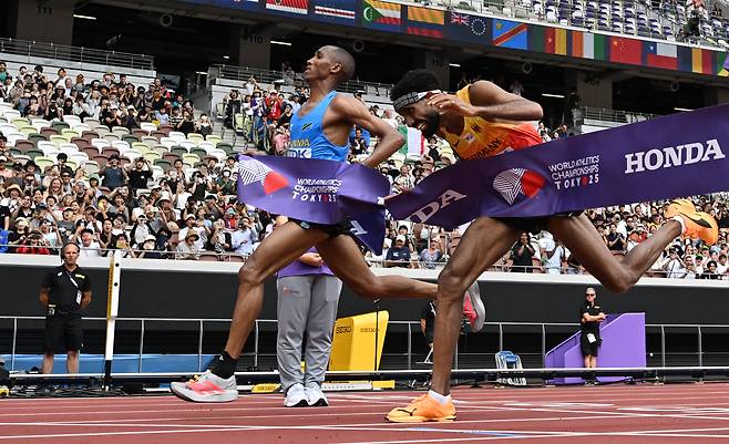 탄자니아의 알폰스 펠릭스 심부(왼쪽)와 독일의 아마날 페트로스가 15일 일본 도쿄에서 열린 세계육상선수권대회 남자 마라톤 결승에서 결승선을 통과하고 있다./ 신화 연합뉴스