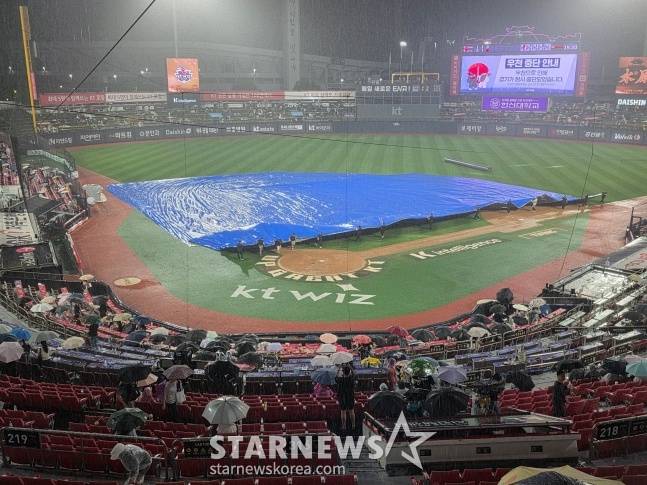 구장 그라운드 키퍼들이 16일 수원KT위즈파크에서 폭우가 쏟아진 그라운드를 방수포로 덮고 있다. /사진=김동윤 기자
