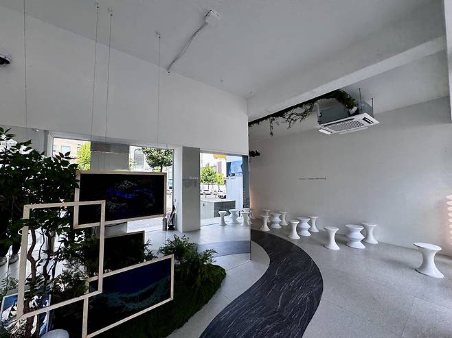 Just past the entrance, visitors move through a minimalist transition space filled with soft natural light, abstract stools and phrases like “Curiosity changes everything” printed on the walls and glass. (Moon Joon-hyun/The Korea Herald)