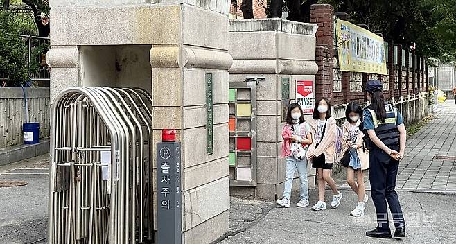 19일 오전 8시께 광주 서구 치평동 운천초등학교. 광주 서부경찰서 경찰이 등교하는 학생들에게 주의를 당부하고 있다.