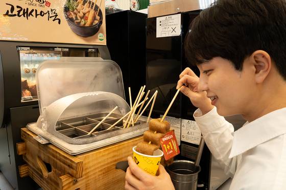 18일 세븐일레븐은 오는 22일부터 동절기 대표 간식인 군고구마와 어묵 5종, 붕어빵 3종 등을 선보인다고 밝혔다. 사진은 고객이 어묵을 고르는 모습. 사진 세븐일레븐