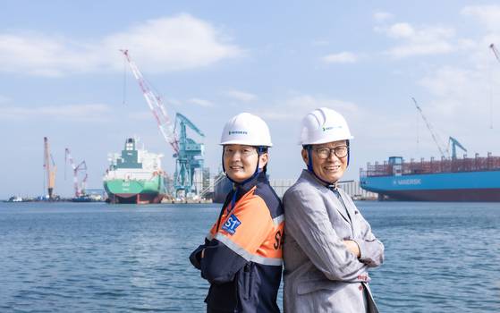 국내 최초로 ‘부자 명장’에 선정된 아버지 고윤열(오른쪽)씨와 아들 민철씨가 지난 16일 울산광역시 동구 HD현대중공업 앞바다에서 서로 등을 맞댄 채 활짝 웃고 있다. 명장은 최고의 숙련 기술을 보유한 장인에게 수여되는 최고의 영예다. 최기웅 기자