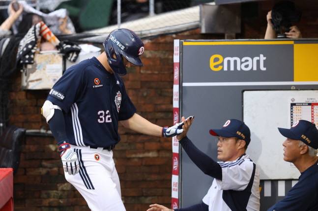 김재환(왼쪽)이 조성환 감독 대행과 하이파이브를 하고 있다. /사진=두산 베어스 제공