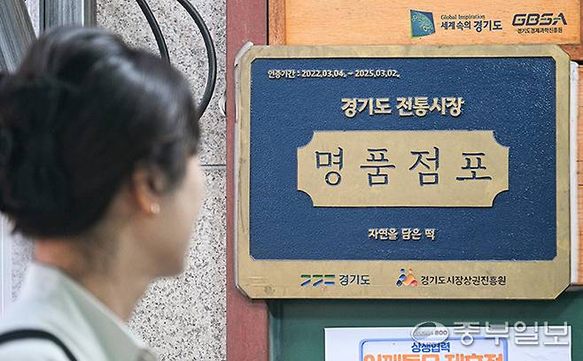 경기도내 우수점포에 3년간 다양한 혜택을 제공하는 '전통시장 명품점포 육성사업'이 예산 부족 및 중복사업을 이유로 별다른 공지 없이 사업을 종료해 인증 점포들이 불편함을 겪고 있는 가운데 22일 오전 수원시 장안구 자연을담은떡 매장에 명품점포 현판이 걸려 있다. 임채운기자