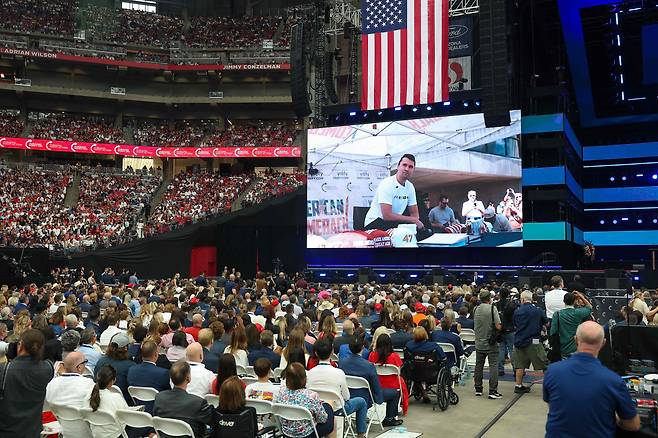 21일 찰리 커크 추모식장에서 지지자들이 커크의 생전 영상을 감상하고 있다. /AFP 연합뉴스