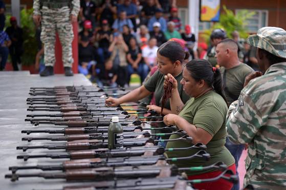 니콜라스 마두로 베네수엘라 대통령이 전국 지역사회에 군대를 배치해 군인과 주민 모두에게 무기 취급 방법 등을 훈련시키라고 지시한 가운데, 베네수엘라 카라카스에서 무기 옆에 서 있는 여성들. 로이터=연합뉴스