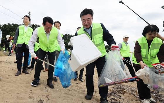 22일 경기도 화성시 궁평항에서 열린 '대한민국 새단장' 행사에서 윤호중 행정안전부 장관, 정명근 화성시장 등 참석자들이 쓰레기를 줍고 있다. 연합뉴스