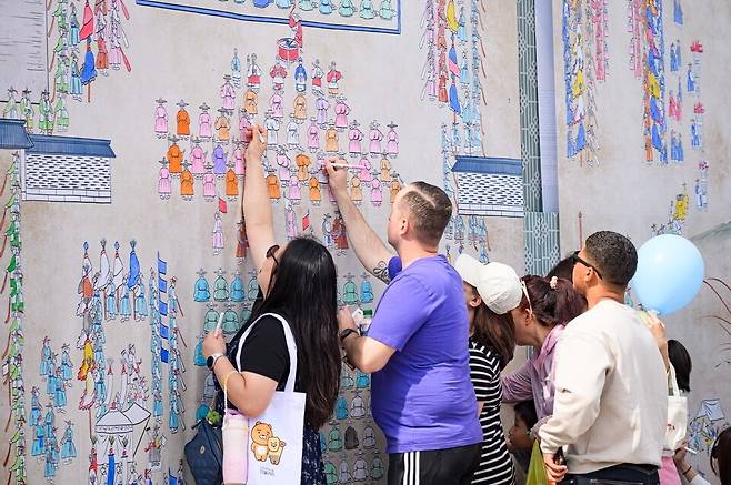 ▲지난해 수원화성문화제에 방문한 외국인 관광객들이 시민도화서에 색을 칠하고 있다. / 사진제공=수원특례시