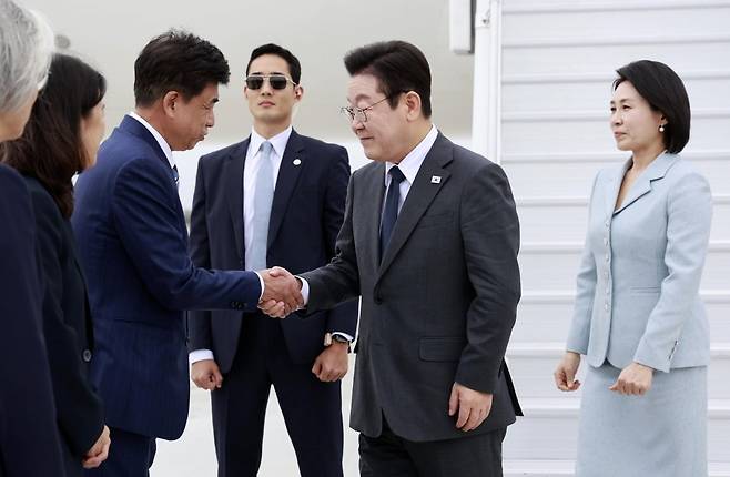 이재명 대통령이 22일(현지시간) 미국 뉴욕 JFK국제공항에 도착해 마중 나와있는 차지훈 주유엔대표부 대사와 악수를 하고 있다. 연합뉴스