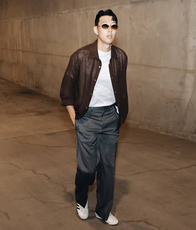 손흥민이 9월 1일(한국시간) 샌디에이고 FC와 MLS 홈 데뷔전을 치르기 위해 홈구장인 BMO 스타디움에 입장하는 모습. 이날 손흥민은 갈색 셔츠에 밑단이 롤업된 회색 와이드 슬랙스를 입었다. 금색 테에 갈색 알이 들어간 선글라스를 포인트 아이템으로 활용했다. 이날 룩은 영국에서 뛸 때보다 미국에서 패션이 더 화려해졌다고 느끼게 하기 충분했다. 사진=LAFC